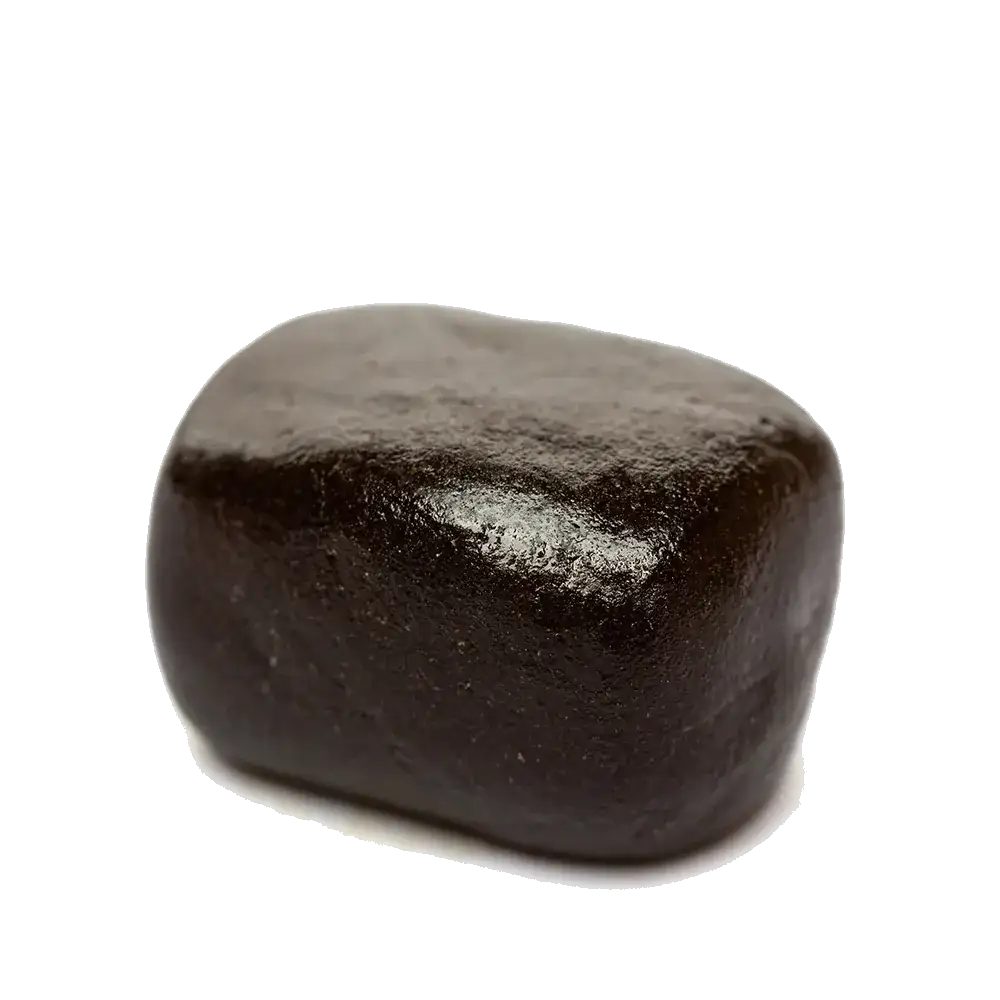 Bloc de résine Afghan Hash CBG, brun foncé et lisse, photographié sur fond clair.