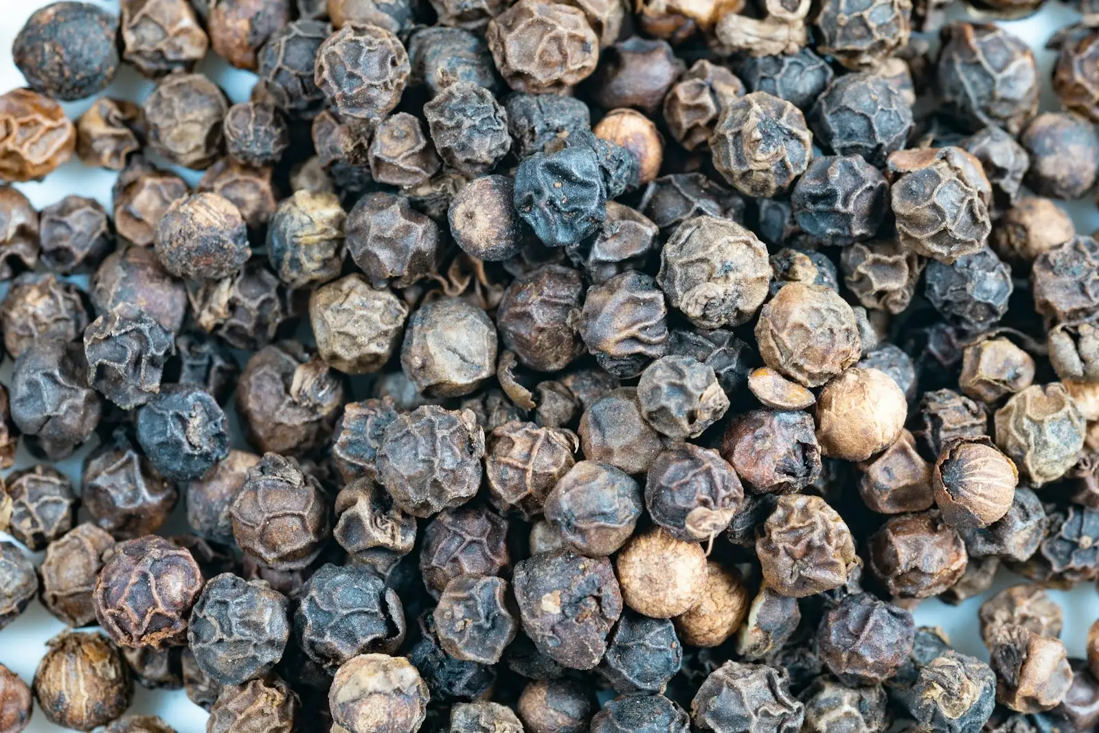 Grains de poivre noir en gros plan, la source alimentaire la plus connue du bêta-caryophyllène