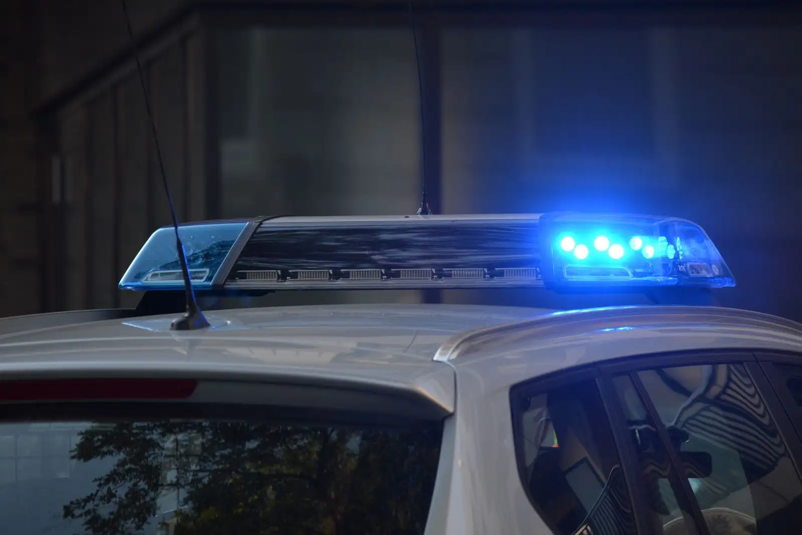 Rampe lumineuse bleue allumée sur le toit d'une voiture de police, de nuit