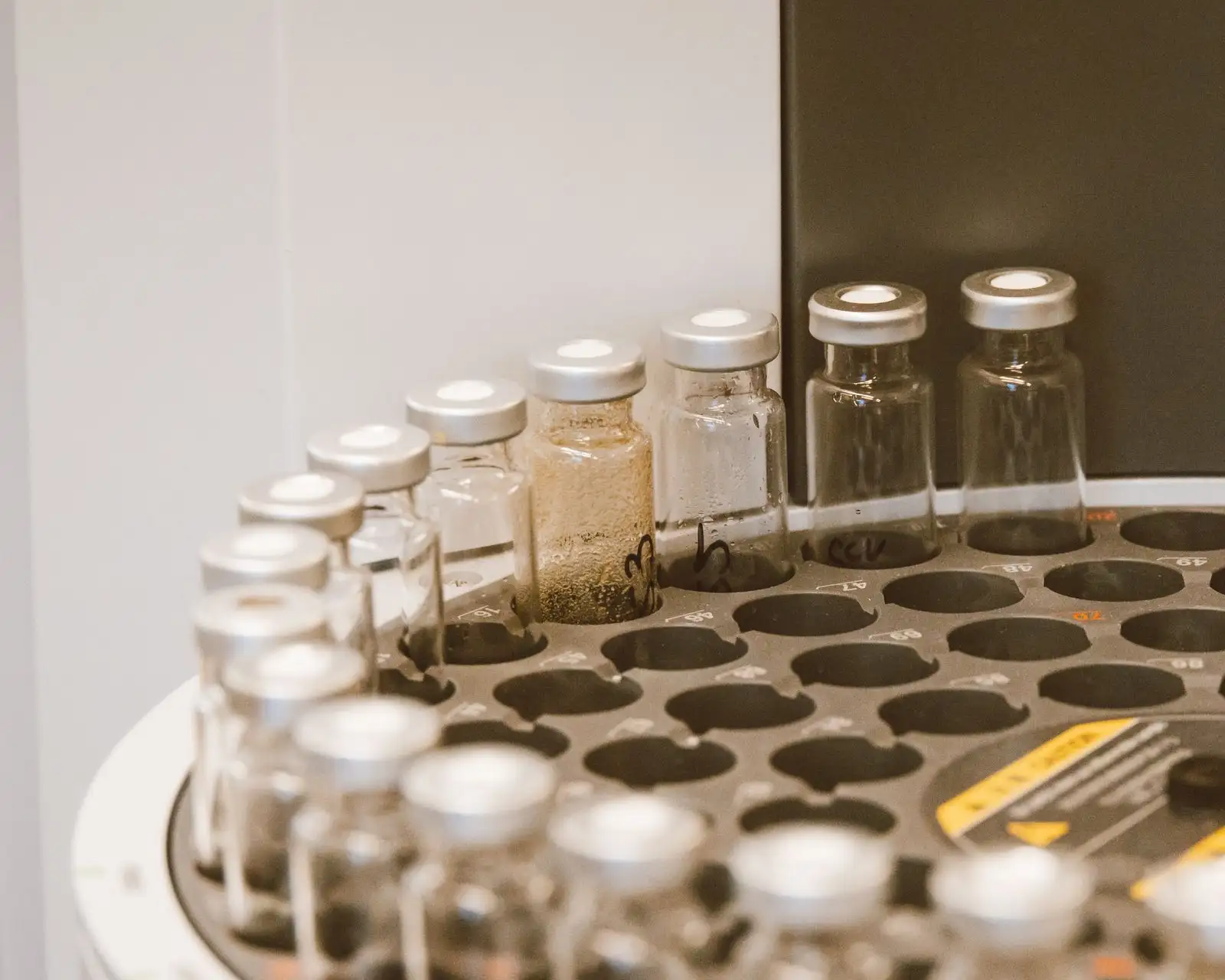 Flacons d'échantillons capsulés dans le plateau d'un passeur automatique de chromatographe, au laboratoire