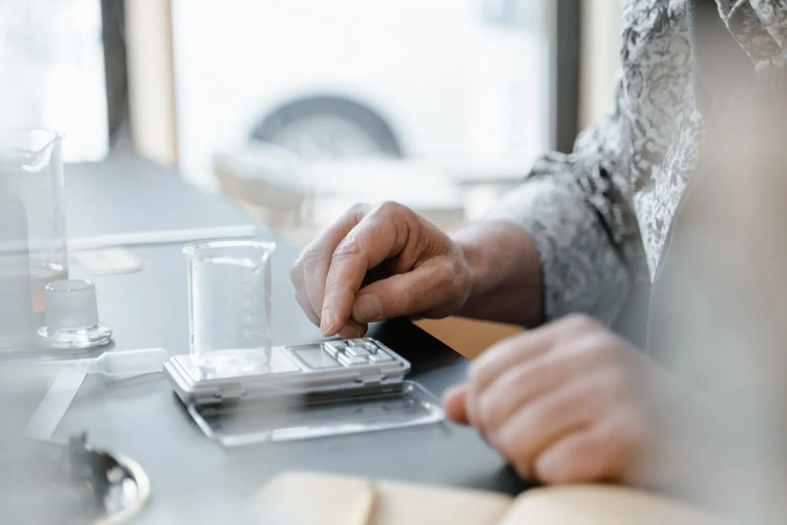 Balance de précision numérique sur une paillasse, avec un bécher posé sur le plateau