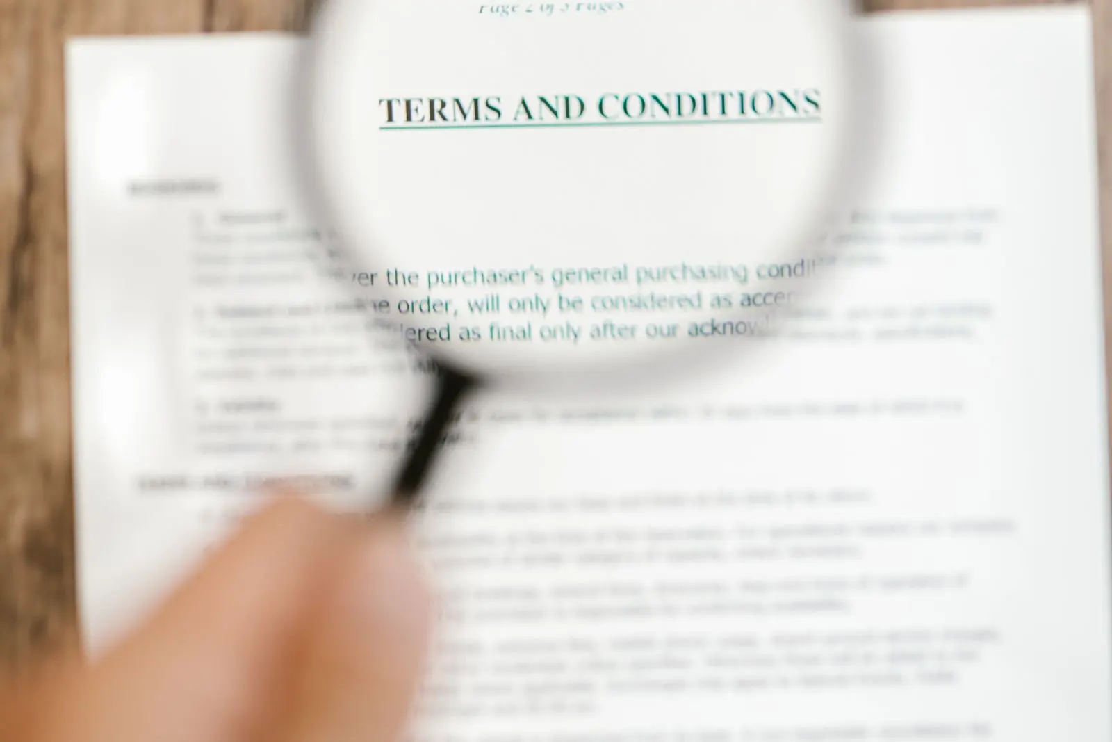 Une loupe tenue au-dessus d'un document imprimé, pour en lire les petites lignes