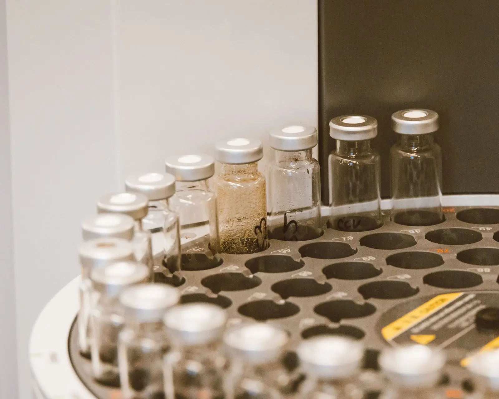 Flacons d'échantillons capsulés dans le plateau d'un passeur automatique de chromatographe, au laboratoire