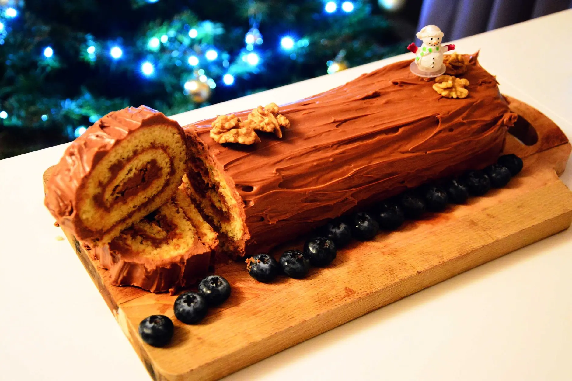 Bûche de Noël au chocolat décorée, sur une table de fête.