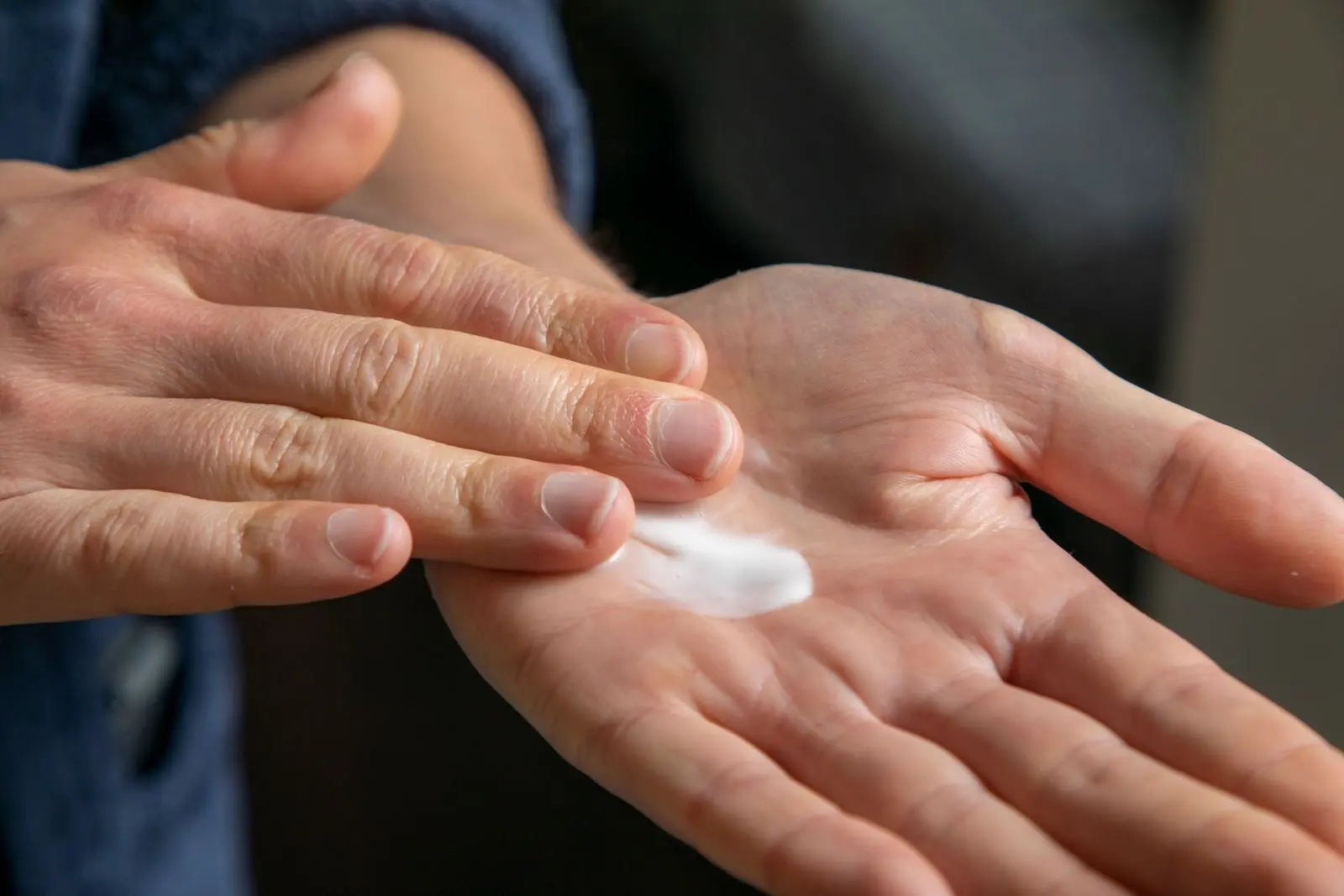 Noisette de crème blanche déposée au creux d'une main, prête à être appliquée