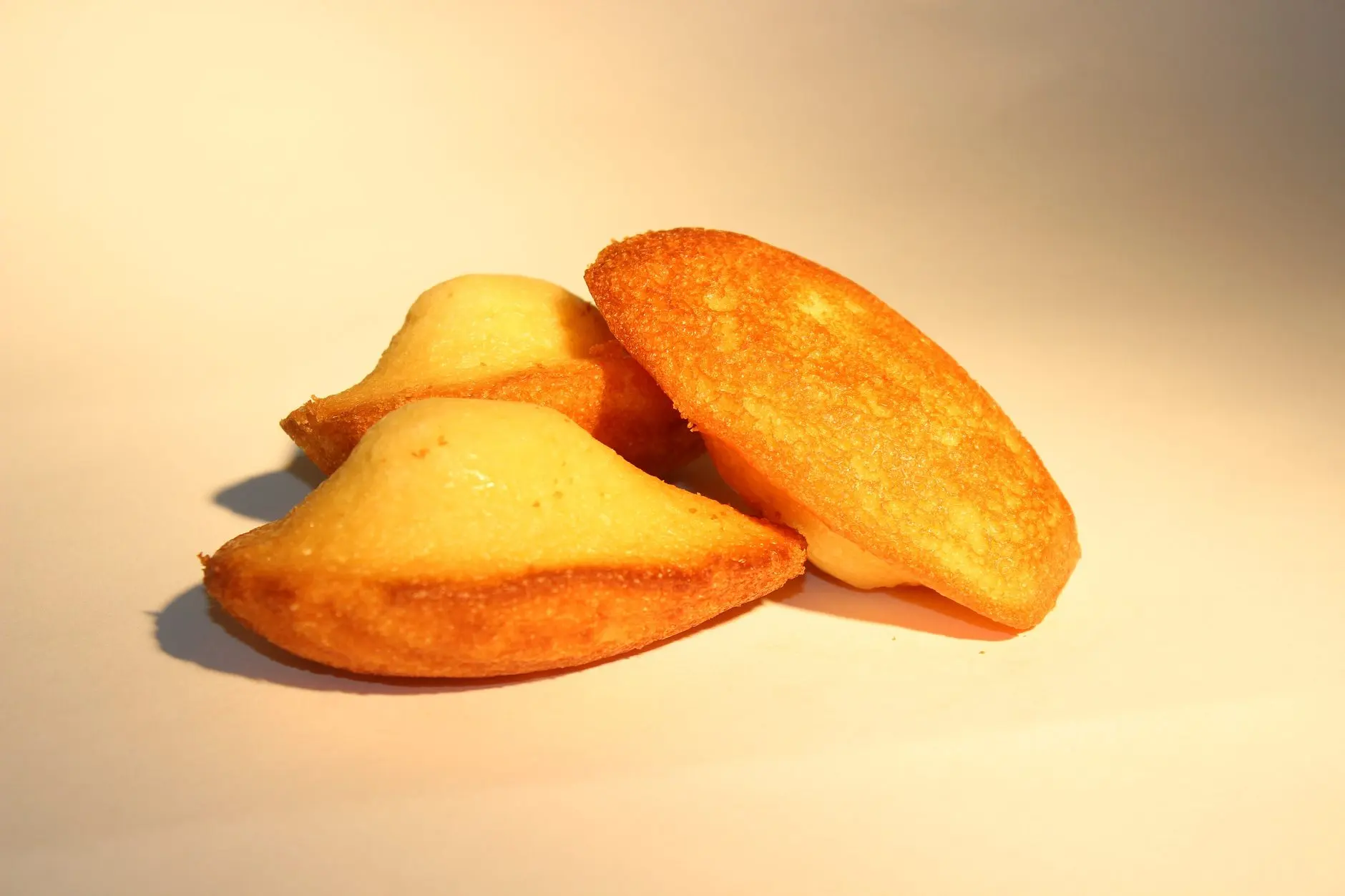 Trois madeleines dorées sur fond clair.