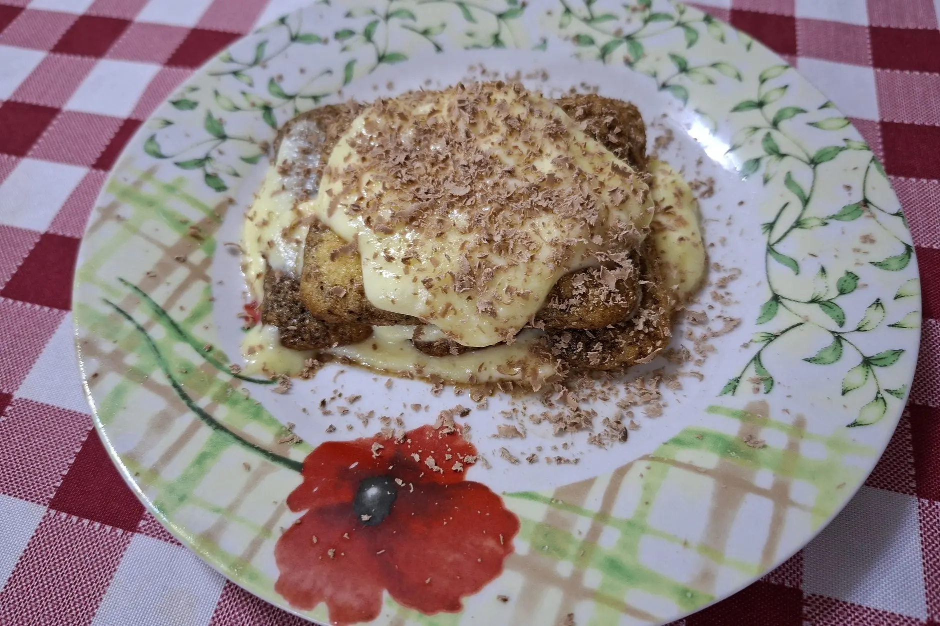 Part de tiramisu saupoudrée de cacao sur une assiette.